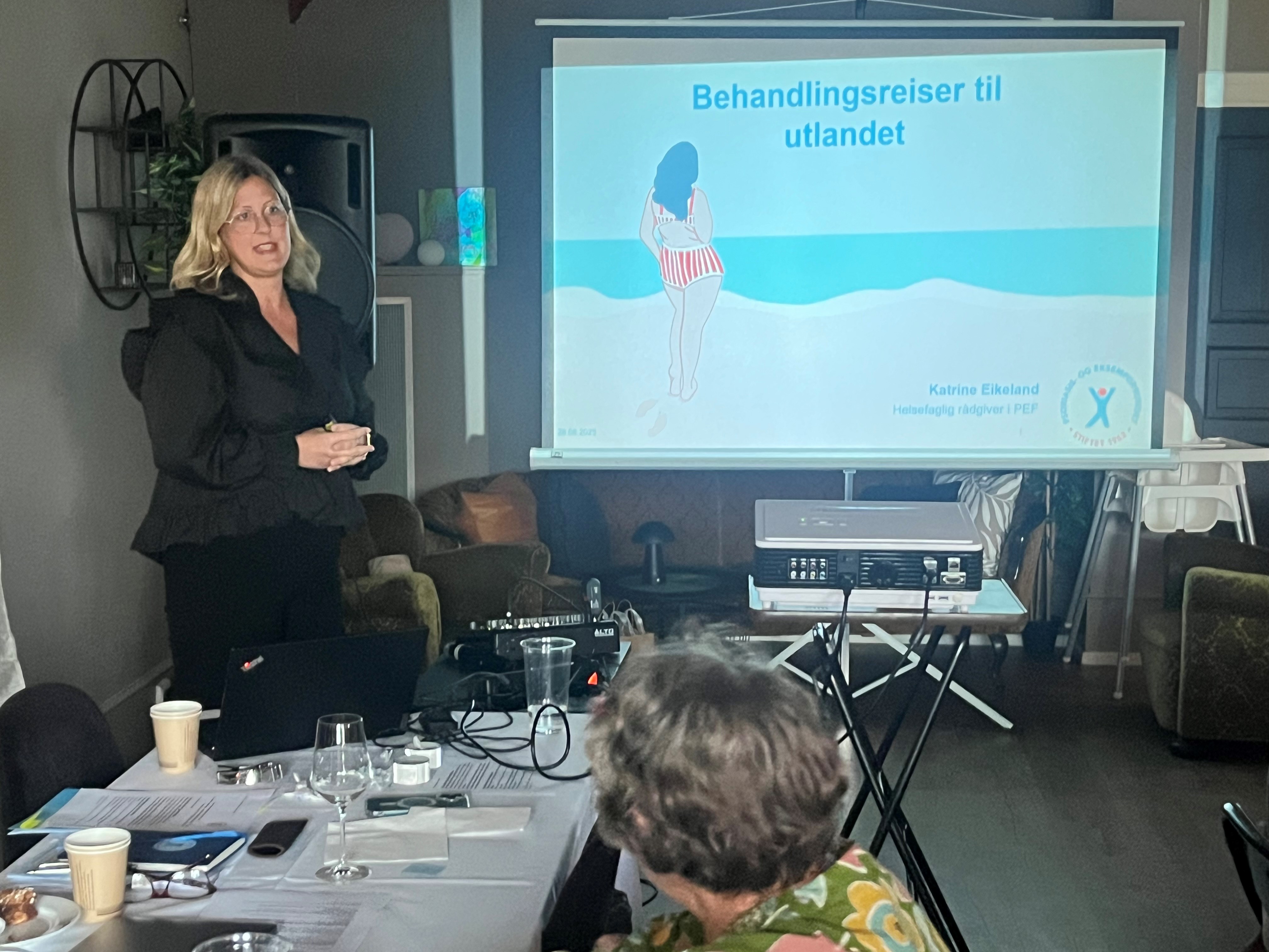 En kvinner holder en Power Point-presentasjon.